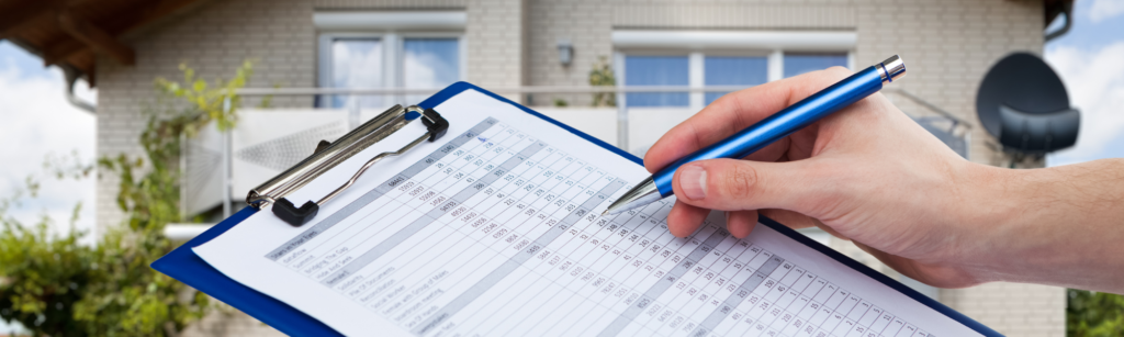 住宅街での定期点検を想起させる、クリップボードの集計表と青いボールペン。