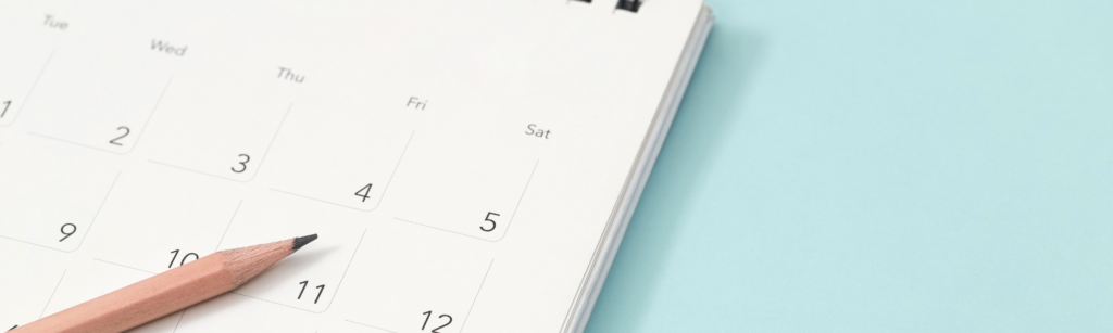 打ち合わせや工程管理をイメージした、清潔感のある白の卓上カレンダーと一本の鉛筆。